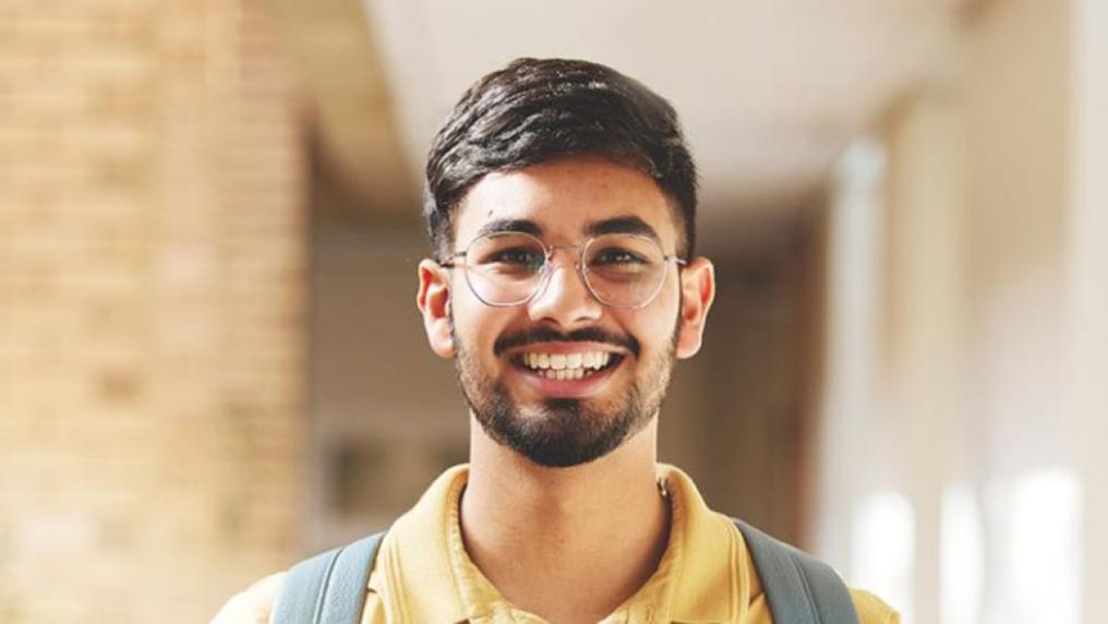 A smiling student wearing a backpack.