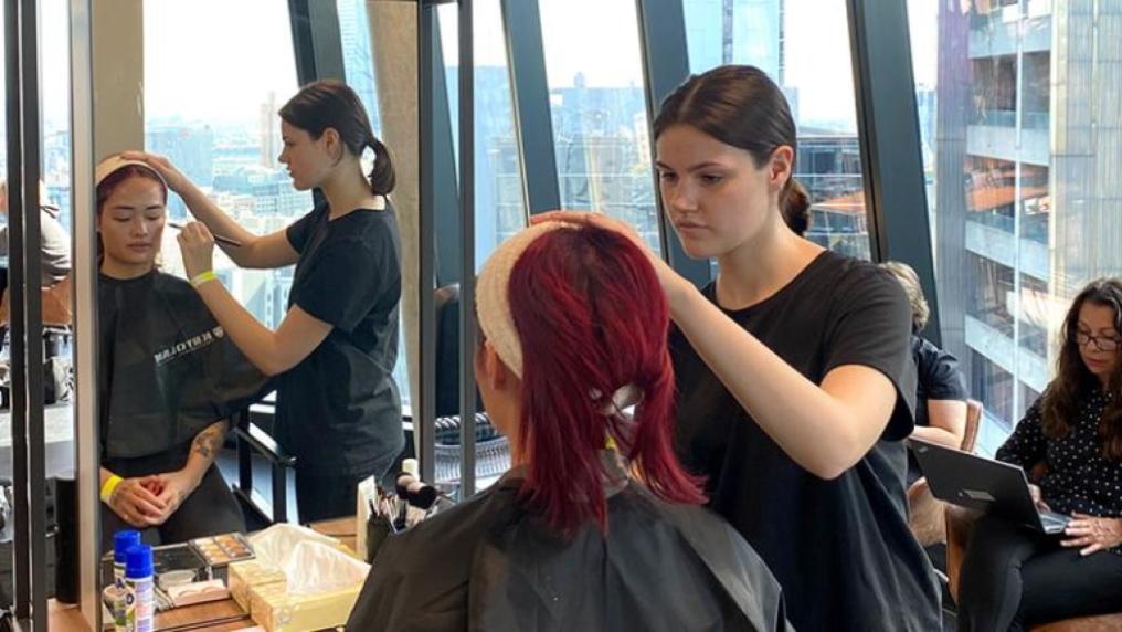 A beauty student doing makeup on a client in the VU City Tower salon.