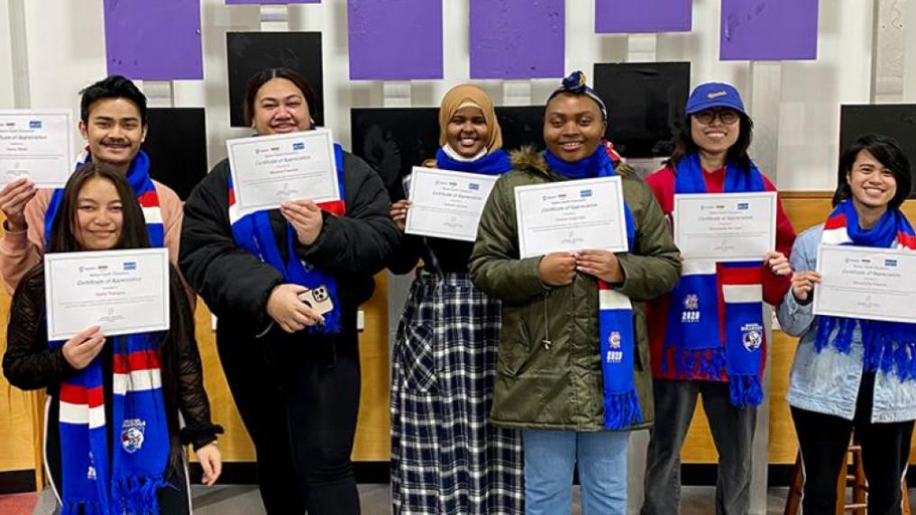6 students of various cultural backgrounds hold certificates, smiling