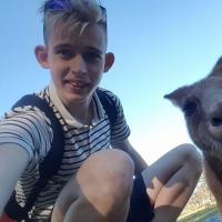 Denis squats to take a selfie with a kangaroo