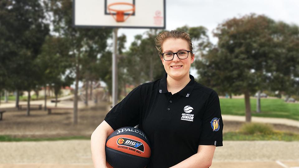 Lauren Tipper holding a basketball on a basketball court