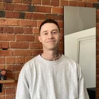 Matt, a barbering student, expresses the value of his VU degree while standing in front of a wall.