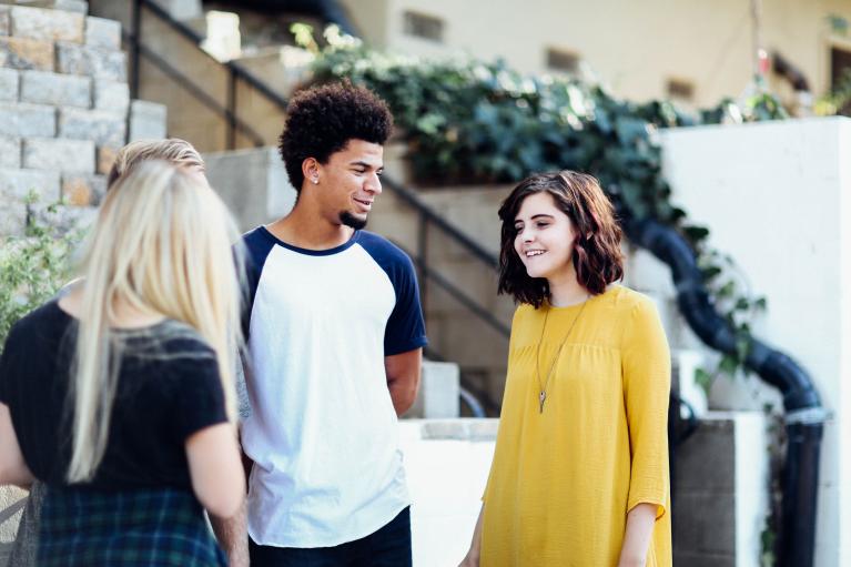 Three people standing and talking