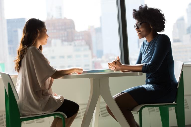 Two people talking at a table.